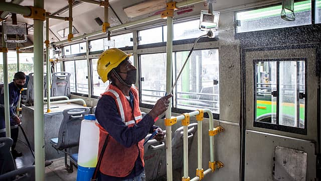 A worker disinfects a bus in New Delhi. A worker disinfects a bus in New Delhi.