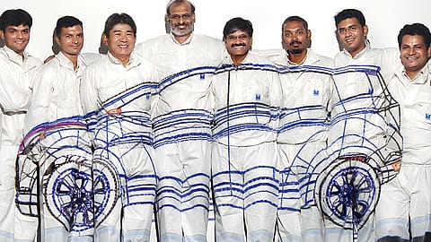 Research on motion: Maruti Suzuki’s R&D team, headed by I.V. Rao (centre), made history by developing the first all-Indian car. Here they pose with the wireframe image of the RLL projected across them.