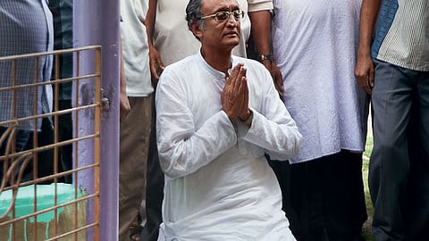 ON HIS KNEE: Amit Mitra at a temple in the Khardah assembly constituency.