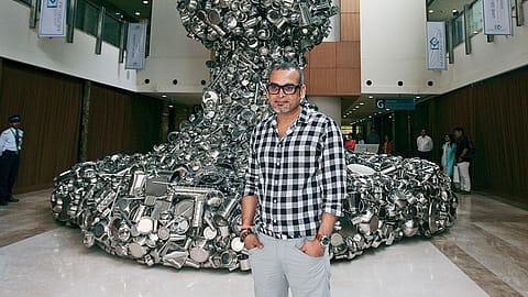 Subodh Gupta in front of his sculpture “Line of Control” made from  stainless steel kitchen utensils.