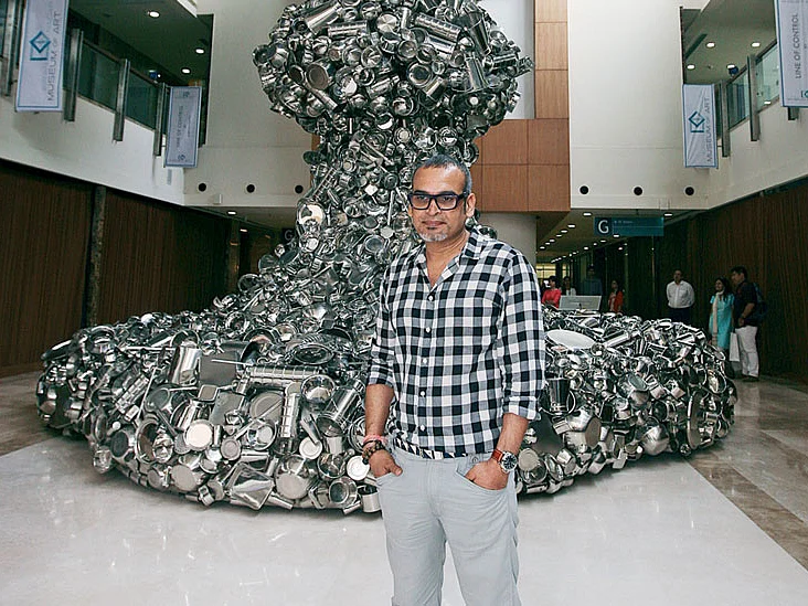 Subodh Gupta in front of his sculpture “Line of Control” made from  stainless steel kitchen utensils.