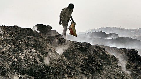 A rag-picker braves the smoke at a dump in Delhi.
