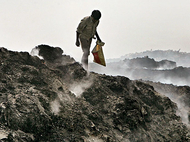 A rag-picker braves the smoke at a dump in Delhi.