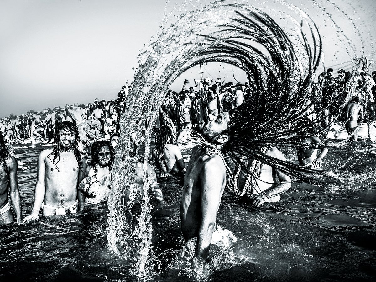Indian sadhus take a dip into the water of the holy Sangam -- the confluence of the Ganges, Yamuna and mythical Saraswati rivers -- during the auspicious bathing day of Makar Sankranti at the Kumbh Mela in Allahabad