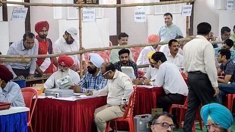 Indian election officials check an Electronic Voting Machine (EVM) at a polling counting centre in Amritsar on May 23, 2019.