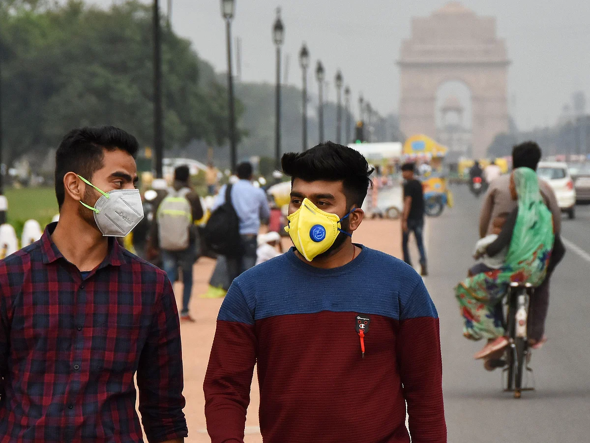 People wearing face masks on a Delhi road close to  India Gate as a preventive measure against the spread of the Coronavirus outbreak.