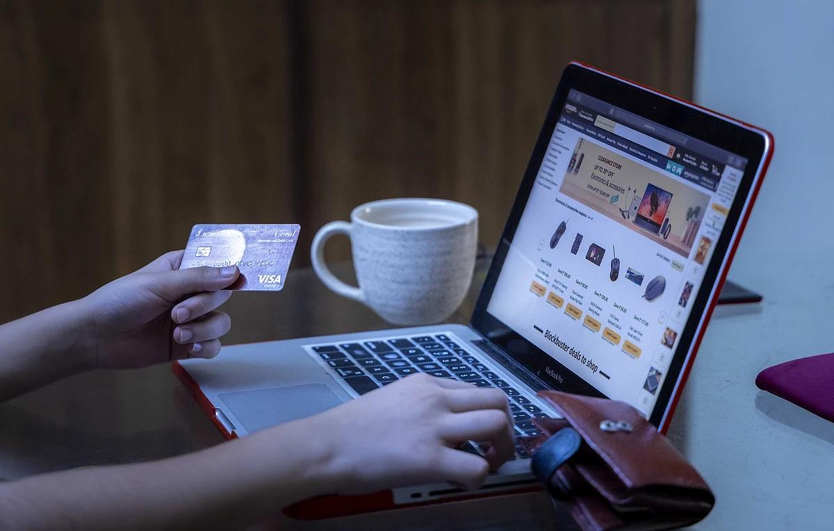 A representational image of a shopper using their card to shop for products on an e-commerce website.