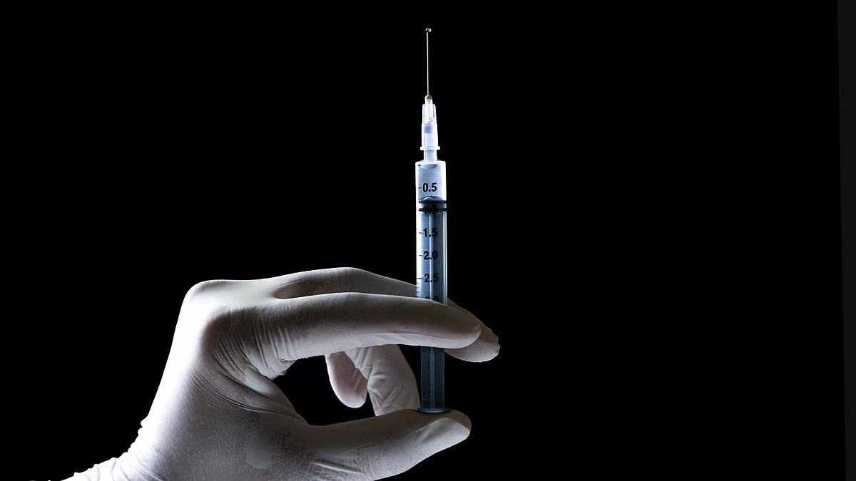 A representational image of a syringe being prepared for administration. 