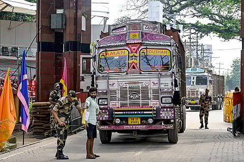 A Border Security Force (BSF) personnel (2L) frisks a truck driver (2R) as he returns to India after delivering supplies to Bangladesh, at the India-Bangladesh border of Petrapole about 100km north east of Kolkata on August 6, 2024.