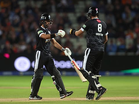 Max Holden and Jamie Overton of Manchester Originals speak in the middle during a The Hundred match in August.